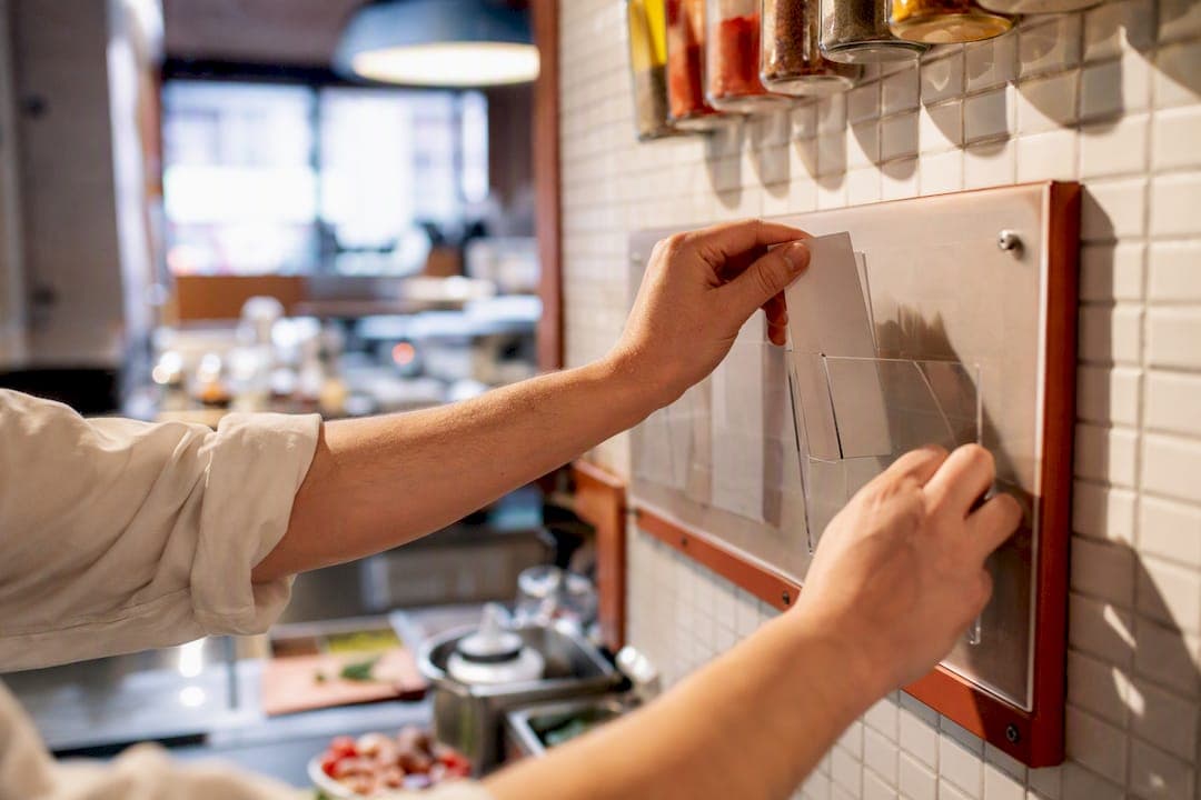 Chef placing order ticket in kitchen