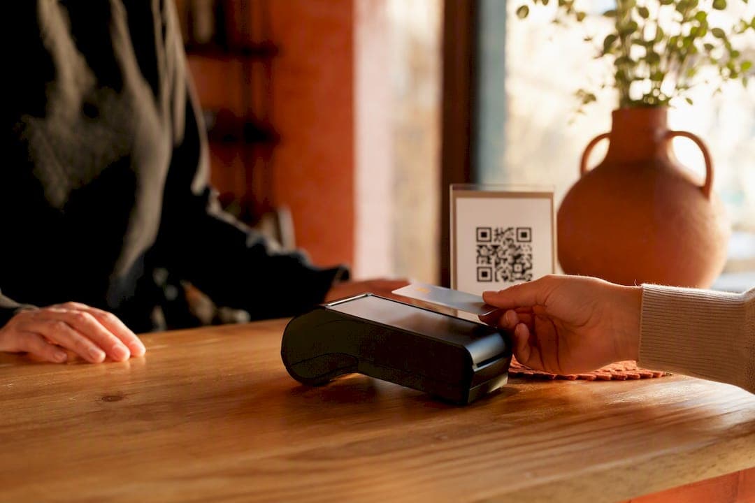 Contactless payment near QR tipping sign on restaurant counter