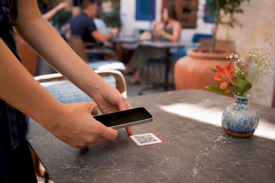Hands scanning table QR code with phone turned off